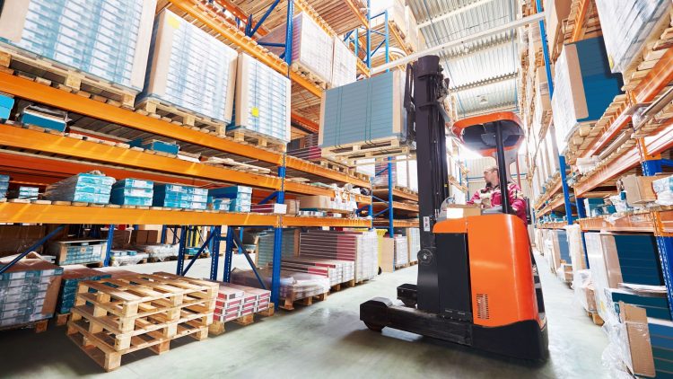 Worker increasing warehouse efficiency by using a narrow aisle reach truck