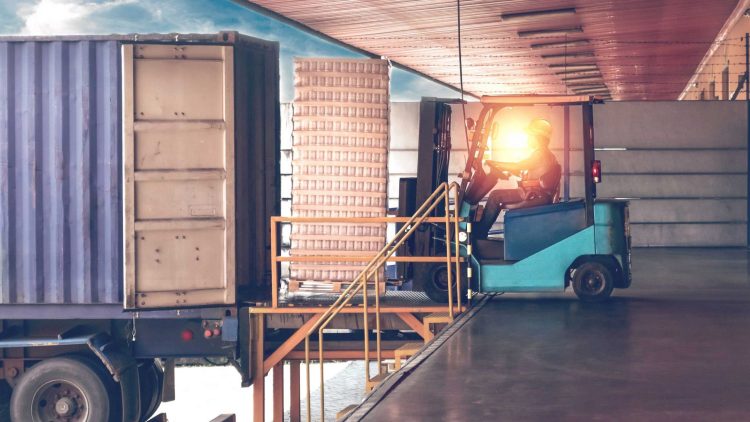 Operator loading and unloading trucks with a forklift