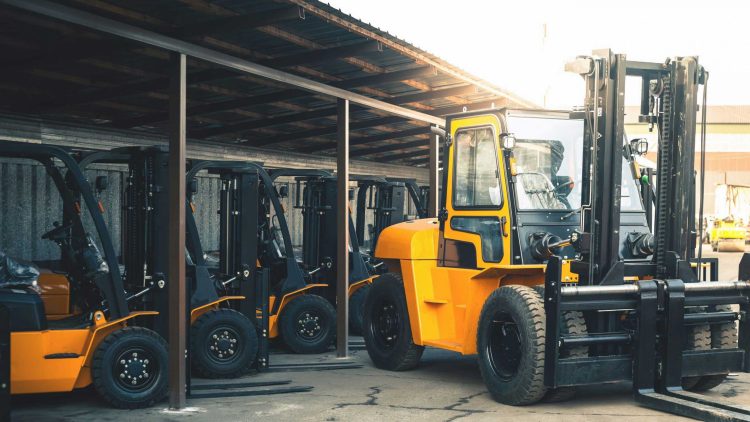 Large yellow forklifts with pneumatic tires undergoing brake inspection