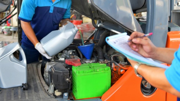 Employees performing regular forklift maintenance